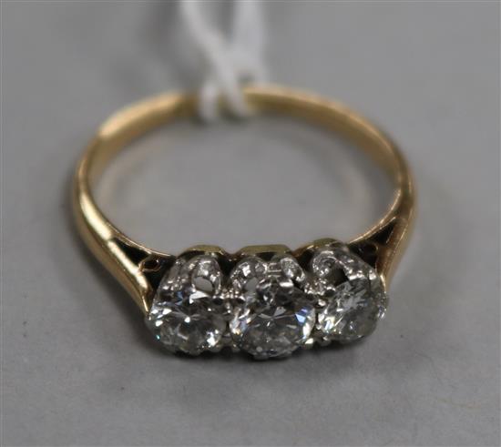 An 18ct gold and platinum three stone diamond ring, size M.